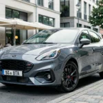 Ford Puma gris Solar finition ST-Line garé dans une rue urbaine moderne avec architecture contemporaine en arrière-plan