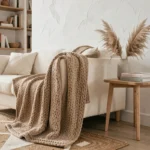 Salon scandinave cosy avec canapé bouclé crème, table en bois clair et décoration végétale en herbes de pampa séchées