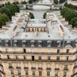Vue aérienne verticale d'un immeuble haussmannien à Paris avec toits en zinc et façades en pierre calcaire
